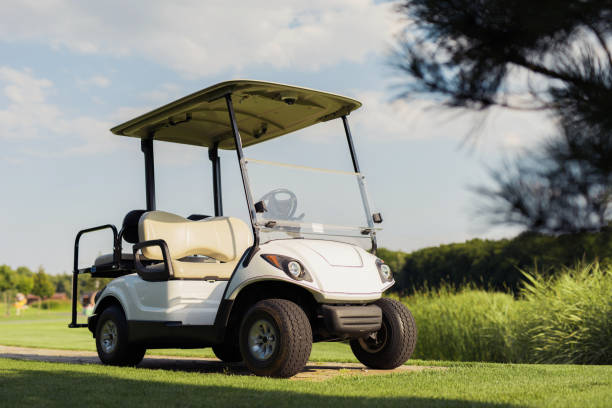 White four-passenger golf cart with a rear seat parked on a golf course on a sunny day.
